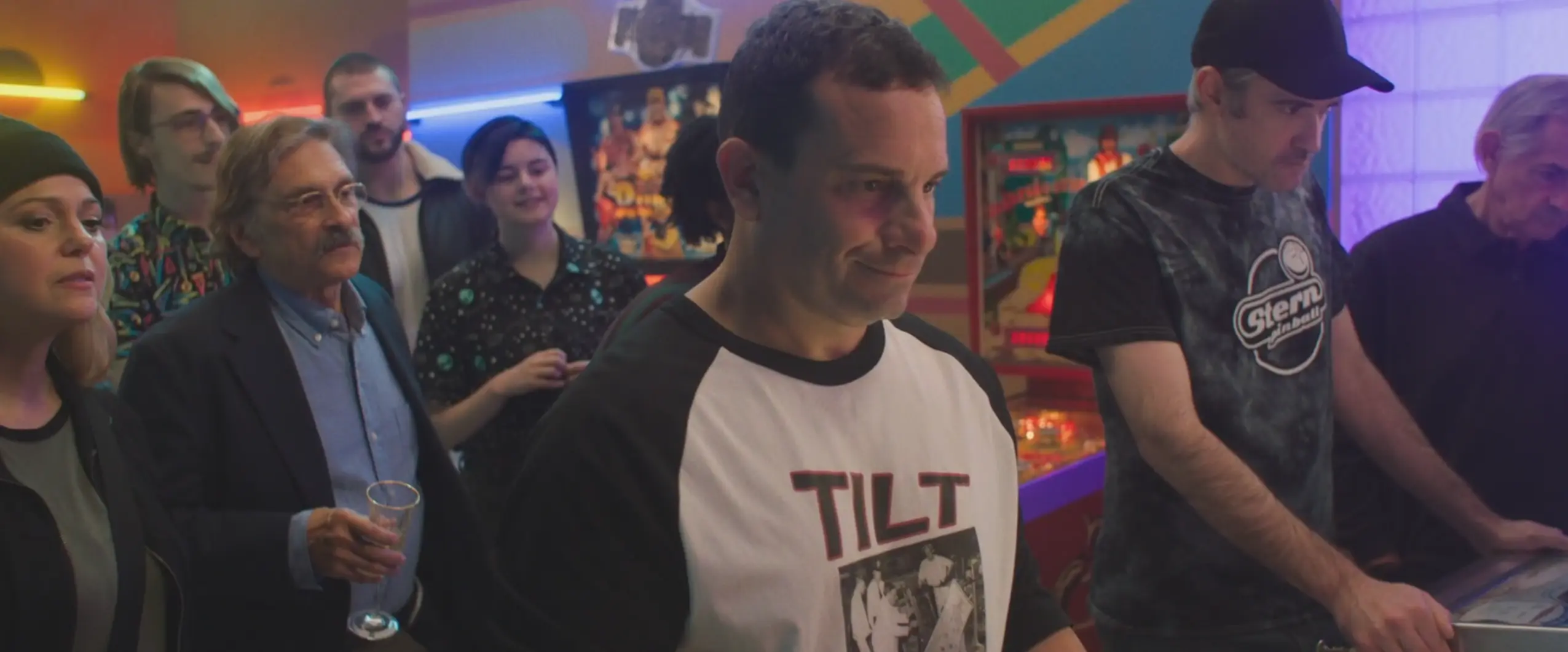 Group of people at arcade with colorful lights and pinball machines